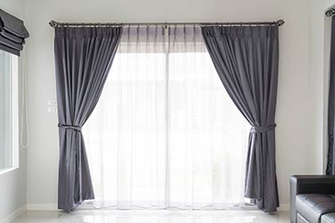 Plush satin curtains and matching shades in stylish home