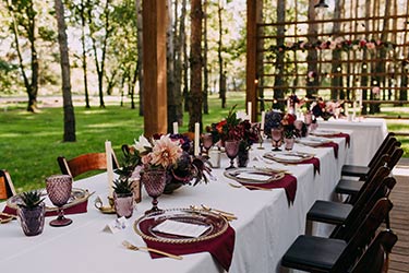 Outdoor floral banquet table in forest setting at dusk