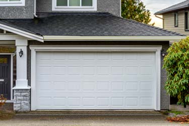 Classic new white sectional garage door on large modern house