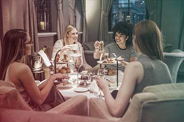 Four women sitting at a table having high tea for a bachelorette party