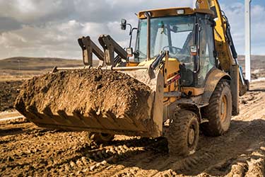 Backhoe Loader moves earth from construction site