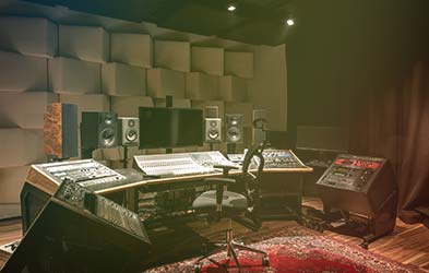 Stylish recording studio control desk with both analog and digital technology in soundproofed room