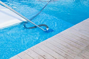 Pool vacuum as part of thorough pool maintenance, resulting in sparkling clean pool water