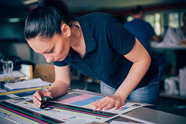 Print shop professional inspects color integrity on wide format prints