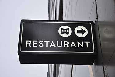 Minimalist signage for restaurant, including directions to nearby public transport