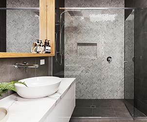 Beautiful tesselated tiling in modern shower of minimalist bathroom