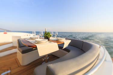 Sunset dinner set up on deck of luxury yacht at sea