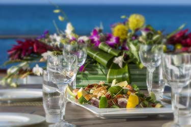Close up of fresh food platter and table setting with florals on deck of luxury yacht